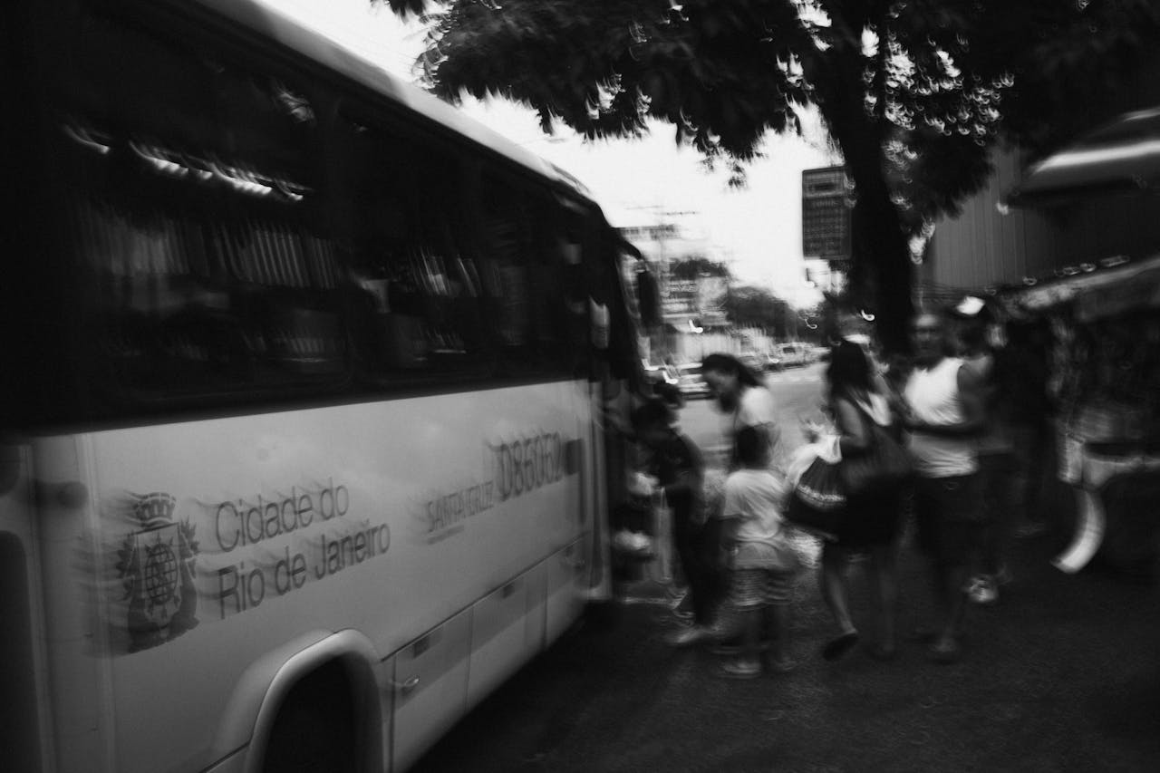 heros-img Blurred black and white photo of people boarding a bus in Rio de Janeiro.
